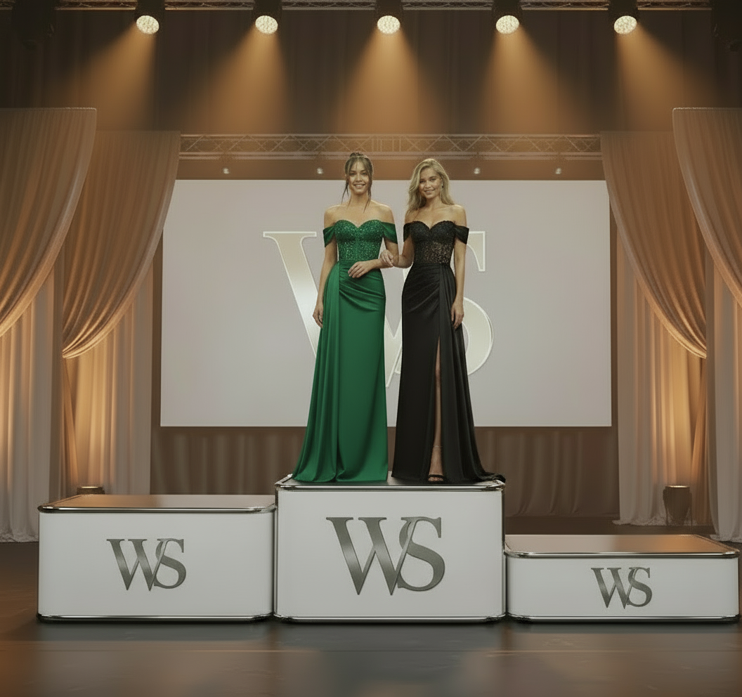Two women in yellow and orange evening gowns standing outdoors with floral decorations.